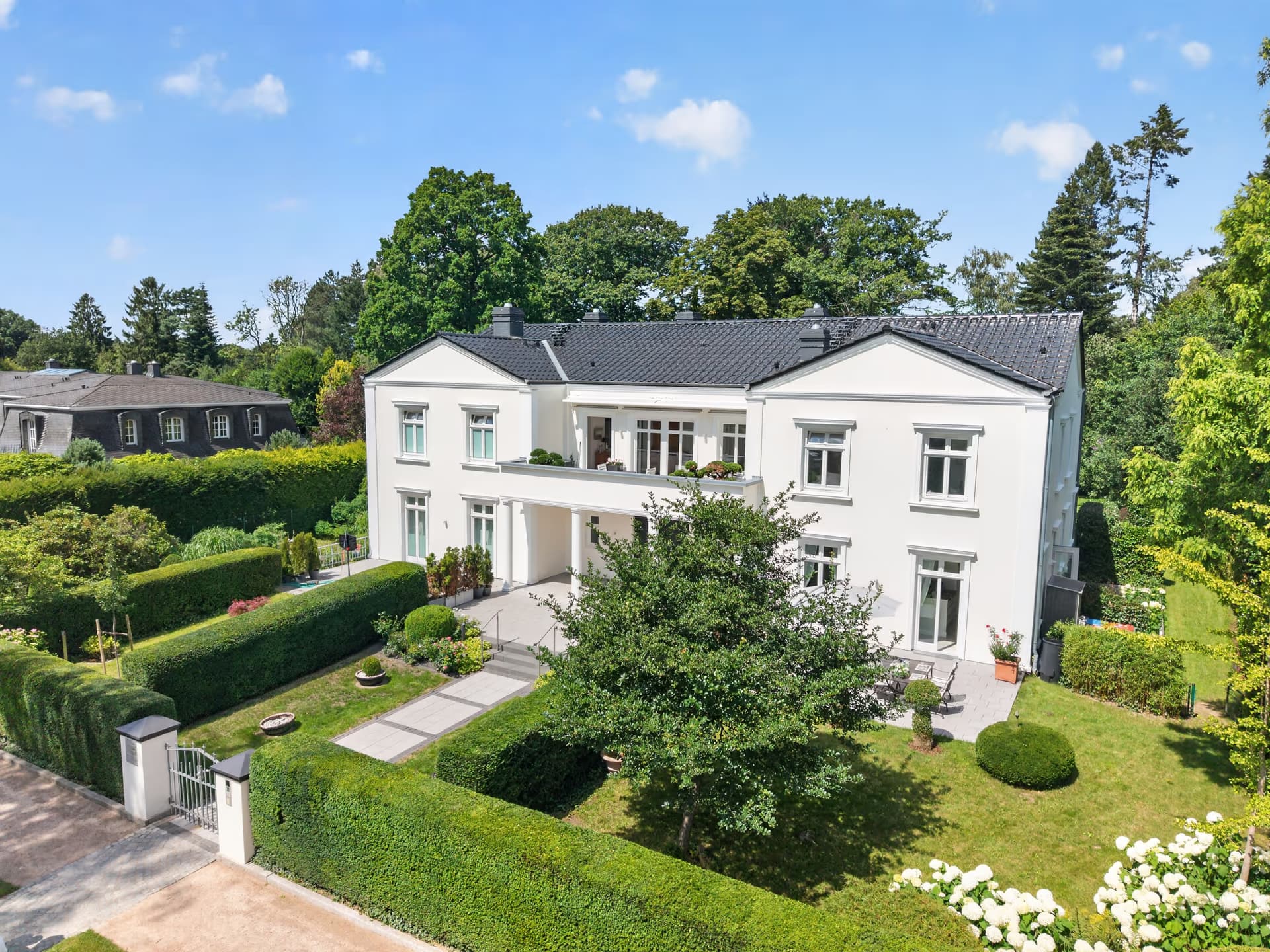 Klassizistische Villa mit Säulenportikus und Formschnitthecken